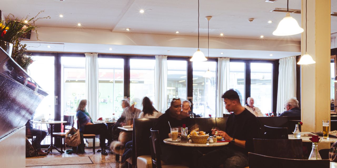 Gut besuchte Caféräumlichkeiten mit heller Glasfront