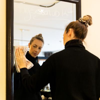 Frau die einen Spiegel mit Angeboten neu beschriftet